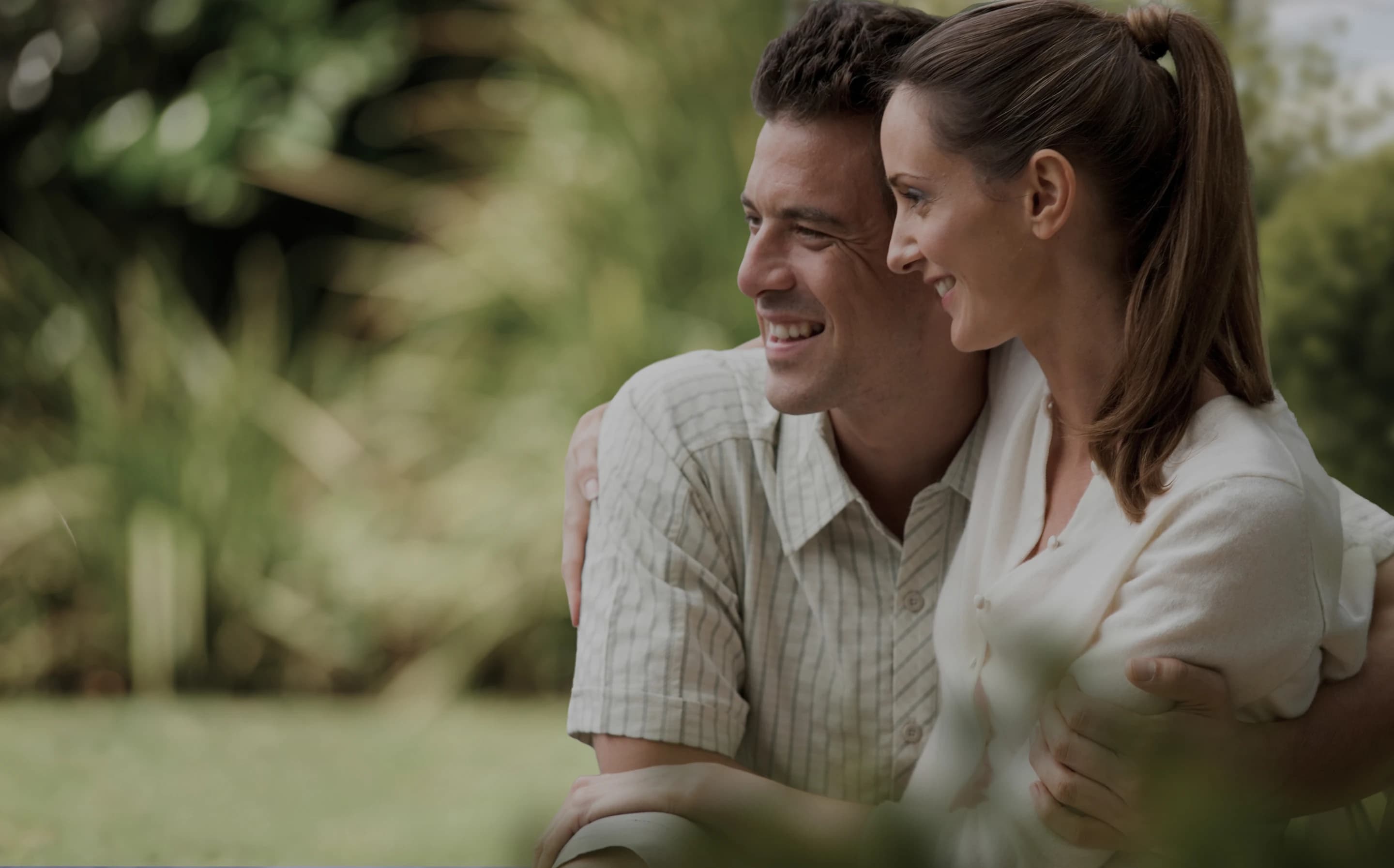 Couple smiling together outdoors in soft evening light