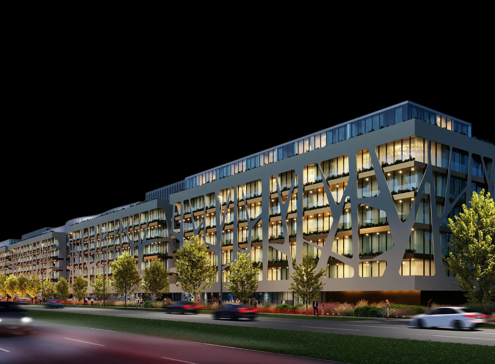 Long residential complex lit up along a quiet street at night